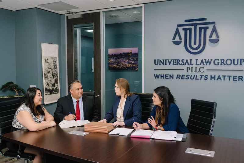 Universal Law Group's criminal defense attorneys reviewing a case with clients at their law office in Houston, Texas