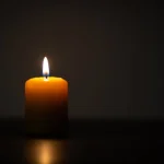 A single lit candle in a dark room - infant wrongful death