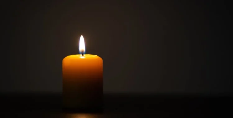 A single lit candle in a dark room - infant wrongful death