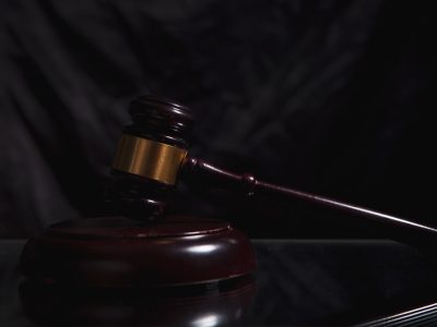 Gavel resting next to a signed legal settlement contract on a wooden desk - how do lawyers negotiate settlements​